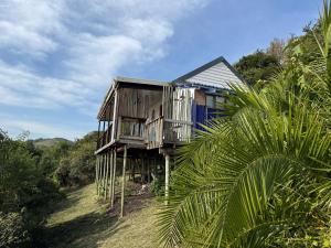 a wooden house sitting on top of a forest at Blue Lagoon 4x4 Cottage in Umngazana