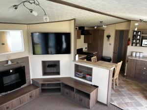 a living room with a flat screen tv and a kitchen at 33 millennium gardens in Whitley Bay