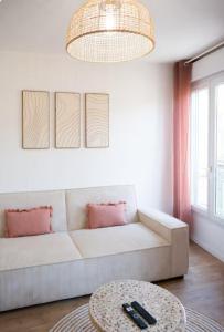 a living room with a white couch and a table at L'écrin rose, appartement coeur de ville de Bergerac in Bergerac