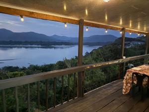 a balcony with a view of a lake at Blue Lagoon 4x4 Cottage in Umngazana +22 photos