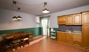 a kitchen with wooden cabinets and a dining table at Il Ciocco Cottages in Castelvecchio Pascoli +32 photos