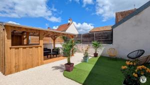 a backyard with a patio with a gazebo at Le coin caché in Arnay-le-Duc