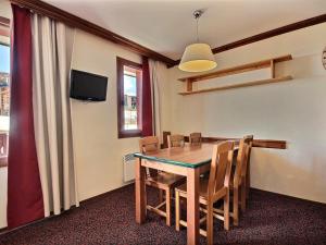 a dining room with a table and chairs and a television at Appartement 3 pièces avec balcon et 2 salles de bains, 6 personnes, Plagne Soleil - FR-1-455-48 in Plagne Villages