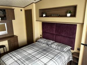 a small bedroom with a bed and a purple headboard at 33 millennium gardens in Whitley Bay