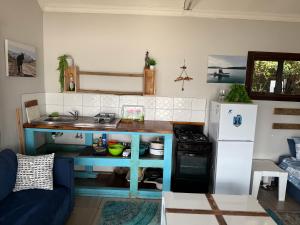 a small kitchen with a table and a refrigerator at Blue Lagoon 4x4 Cottage in Umngazana