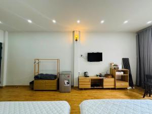 a room with two beds and a tv on a wall at Chất Homestay- Ngay Bến Ninh Kiều in Can Tho