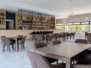 Un restaurante con mesas y sillas y un bar. en Louisville Resort, en Midrand