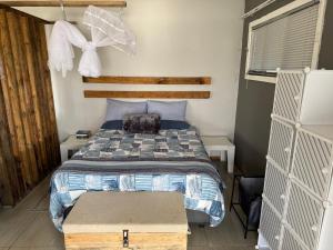 a small bedroom with a bed and a window at Blue Lagoon 4x4 Cottage in Umngazana