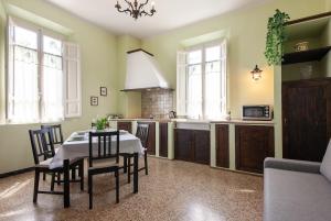 Una cocina con una mesa y sillas en una habitación. en B&G Menconi Edera, en Castelfranco di Sotto 7 fotos más