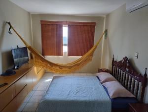 un'amaca in una camera da letto con letto e televisore di Apartamento a Luis Correia