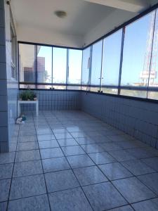una stanza vuota con grandi finestre in un edificio di Apartamento a Luis Correia