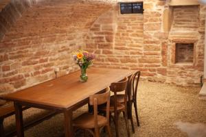 a wooden table with a vase of flowers on it at Maison de vacances avec cave voûtée entre Lyon et Beaune in Givry