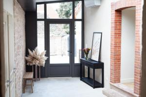 aoyer with a black door and a brick wall at Maison de vacances avec cave voûtée entre Lyon et Beaune in Givry