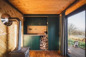 a kitchen with a wood stove in a room at Tiny Glamp - Kontejner Šikmina in Dolní Moravice