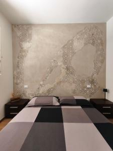a bedroom with a black and white bed and a wall at Il piazzolo, un angolo di storia in Carobbio degli Angeli