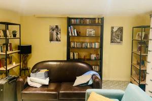un salon avec un canapé en cuir et des étagères dans l'établissement Mas de la Cadenière, à Saint-Rémy-de-Provence