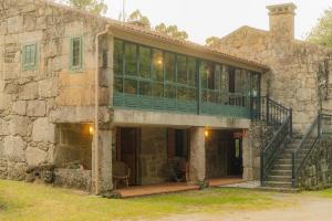 an external view of a stone house with a balcony at Casa Do Cribeiro in Ponteareas