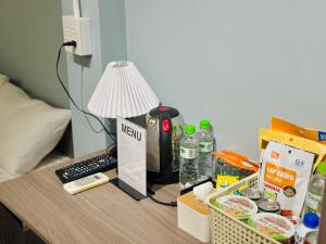 a desk with a lamp and some food on it at Chất Homestay- Ngay Bến Ninh Kiều in Can Tho