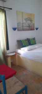 a room with two beds and a chair and a window at Γοργονα in Milína