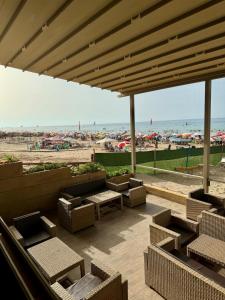 a patio with chairs and tables and a beach at Évasion à deux pas de la mer in Saïdia
