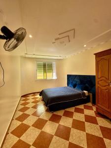 a bedroom with a bed and a checkered floor at Évasion à deux pas de la mer in Saïdia