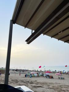 a group of people on a beach with umbrellas at Évasion à deux pas de la mer in Saïdia +3 photos