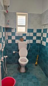 a bathroom with a toilet and a window at Coco farm in Pāmban +8 photos