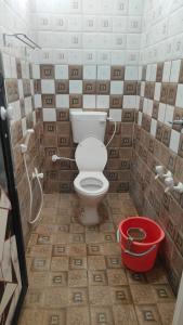 a bathroom with a toilet and a bucket at Coco farm in Pāmban
