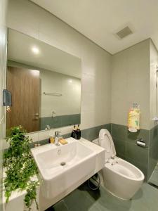 a bathroom with a sink and a toilet and a mirror at 1BR Supper King View Vip Luxury in Long Bình