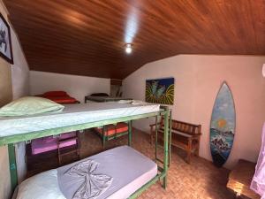 a room with two bunk beds and a surfboard at OSA SURF House in Puerto Jiménez
