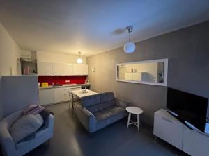 a living room with a couch and a kitchen at Prague Cozy Hideaway in Lysolaje