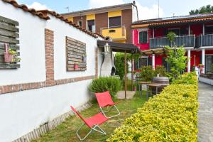 two red chairs in the yard of a house at CASA APPARTAMENTO VACANZE La fermata delle rondini in Castello di Annone