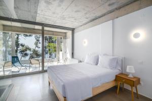 une chambre avec un grand lit et un balcon dans l'établissement Pefka Luxury Homes, à Kalivia Poligirou 103 autres photos