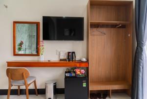 a room with a desk with a tv and a chair at Soha Hotel Cần Thơ in Cái Răng