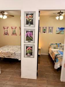 a room with two beds and flowers on a wall at Santa Cosy Villa B Fast Wi-Fi, Netflix Included Split system Air-con & Hot Shower in Santa Rosa +24 photos