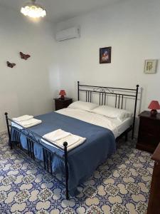 un lit dans une chambre avec un sol bleu et blanc dans l'établissement Casa K2 Stromboli, à Stromboli