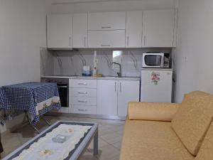 a kitchen with white cabinets and a white refrigerator at Cozy Apartment in Delvinë in Delvinë