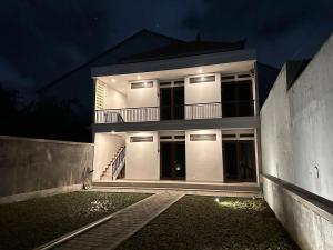 ein weißes Haus bei Nacht mit eingeschalteten Lichtern in der Unterkunft Casa Nika Kerobokan in Kerobokan