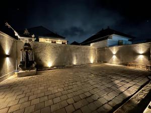 eine Terrasse mit Lichtern an einer Wand bei Nacht in der Unterkunft Casa Nika Kerobokan in Kerobokan