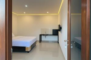 ein kleines Schlafzimmer mit einem Bett und einem Schreibtisch in der Unterkunft Casa Nika Kerobokan in Kerobokan