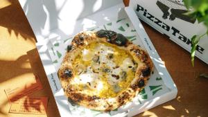 a small pizza in a box on a table at SOIL Nihonbashi Hotel in Tokyo