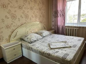 a bedroom with a bed with a white bedspread and pillows at Назарбаева 204 in Pavlodar