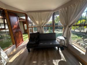 a living room with a couch in front of windows at Suite Dreams Garden Dream Cottage in Panorama
