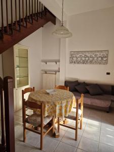 a dining room with a table and chairs and a couch at appartamento a due passi dal mare in Francavilla al Mare