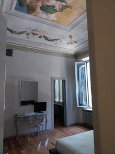 ein Schlafzimmer mit einem Schreibtisch und einem Gemälde an der Decke in der Unterkunft Da Simo in Siena