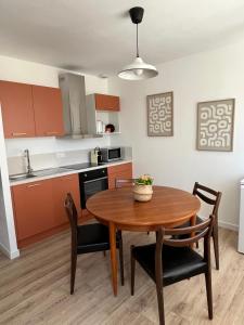 una cucina e una sala da pranzo con tavolo e sedie in legno di La petite Maison Mima a Le Champ-sur-Layon