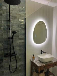 un bagno con lavandino e specchio di La petite Maison Mima a Le Champ-sur-Layon Altre 4 foto