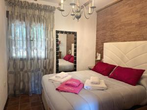 a bedroom with a bed with towels and a mirror at VTAR El Manantial Burunchel in Burunchel +72 photos