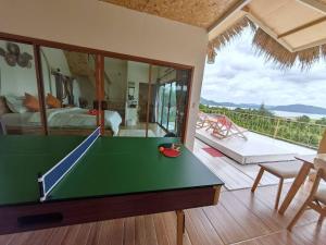 a living room with a pool table and a bedroom at บ้านฟาร์มรักพูลวิลล่าวิวทะเลสาปแก่งกระจาน in Kaeng Krachan