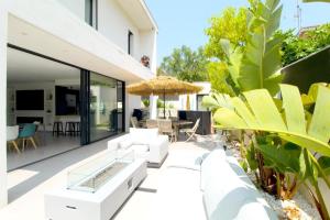 an outdoor patio with white furniture and plants at SUPERBE Villa PISCINE moderne - Cap brun - plage de Toulon in Toulon
